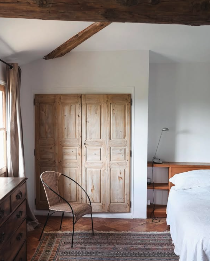 A bedroom with white linen and exposed beams